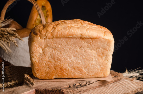 Appetizing fresh culinary pastry - white bread loaf on wooden photo