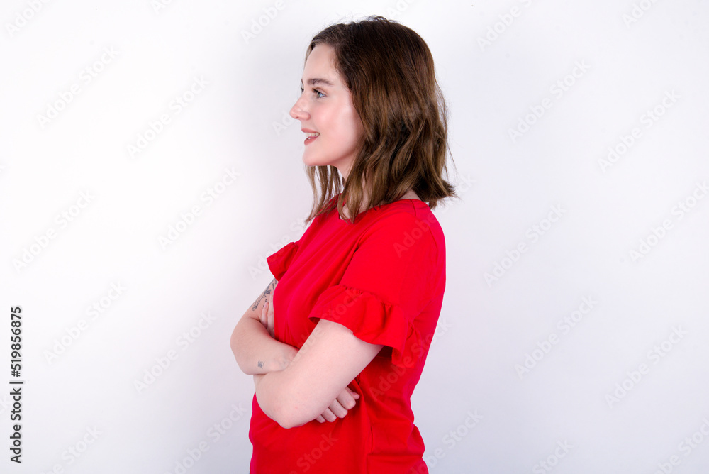 young caucasian woman wearing red T-shirt over white background cross hands look copy space young caucasian woman wearing red T-shirt over white background cross hands look copy space