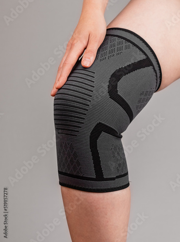 Woman wearing knee pad to reduce pain. Sprained, ruptured ligaments, meniscus tear, tendinitis, arthritis. Health problems, medical conditions concept. High quality photo