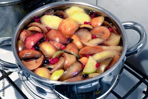 Freshly brewed fruit compote in a saucepan close-up photo