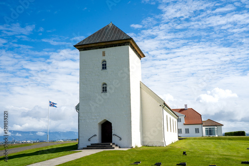 Álftanes, Iceland - July 1, 2022 Landscape view of the church of the Bessastadir, a modest group of white, red-roofed buildings that is the  official residence of the president of Iceland. photo