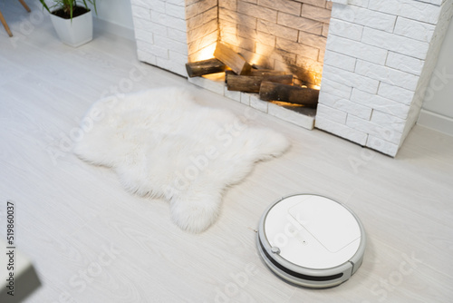 Automated vacuum cleaning robot powered by rechargeable battery in modern living room