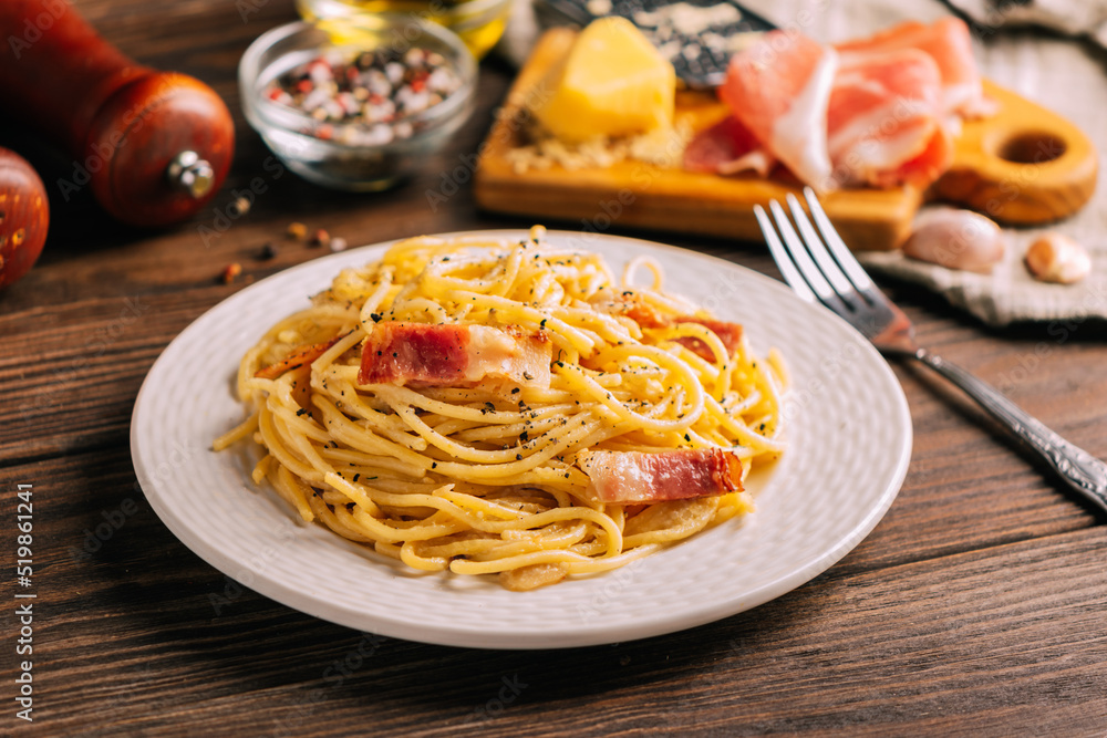 Classic italian pasta carbonara on white plate wooden tabletop, Close-up selective focus Classic italian pasta carbonara on white plate wooden tabletop, Close-up selective focus