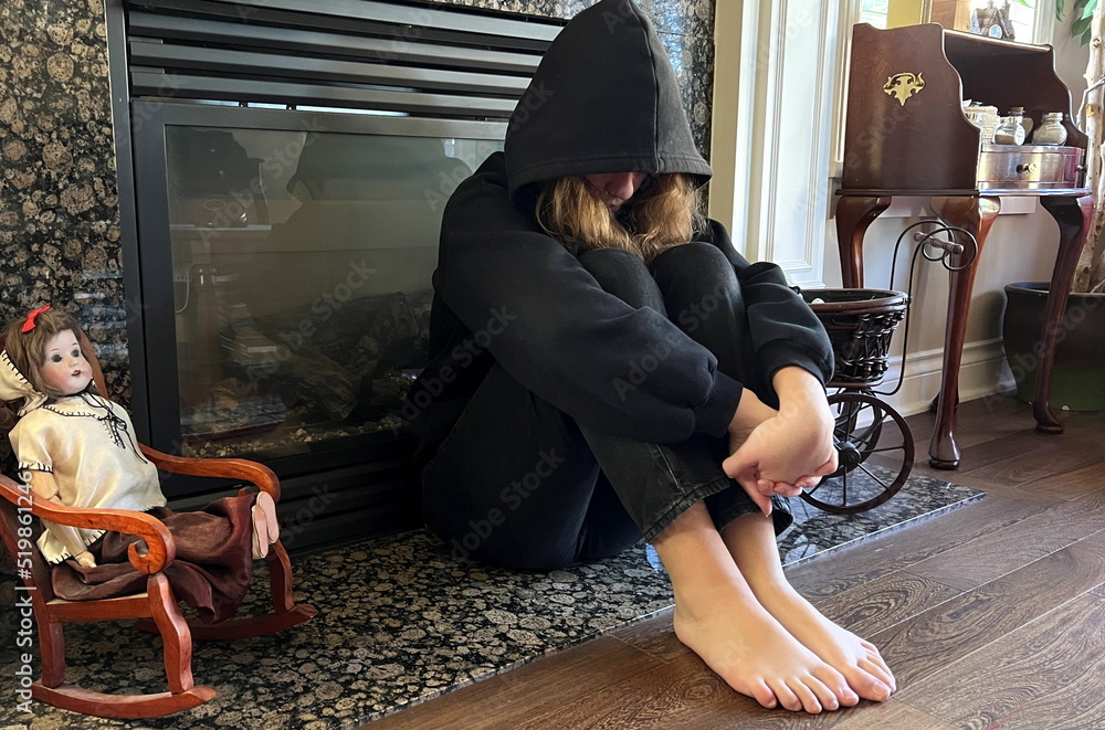 offended teenager teenager girl sitting by the fireplace with her legs