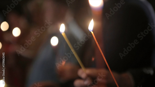 Lighting A Candle With A Match To Get A Romantic Candlelight. Amazing andles and candlesticks are on the table. Stay lights with the peaceful background of religious ceremony. photo