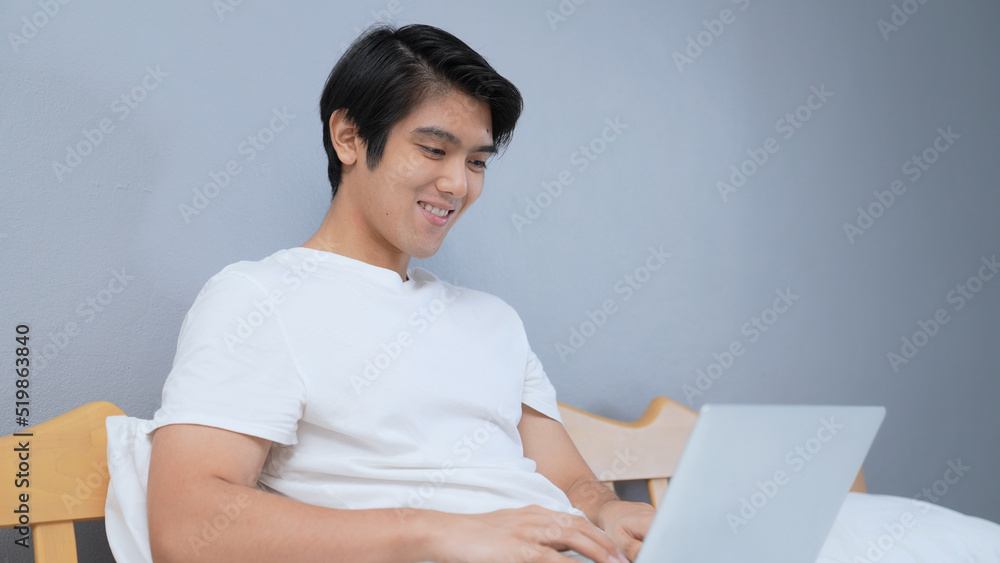 Holiday concept of 4k Resolution. Asian man using computer for video call in bedroom. Holiday concept of 4k Resolution. Asian man using computer for video call in bedroom.
