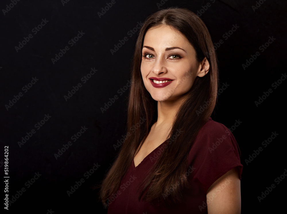 Beautiful young business toothy smiling woman thinking and looking happy in burgundy blouse and with red lipstick on dark black background with empty copy space. Portrait closeup front center