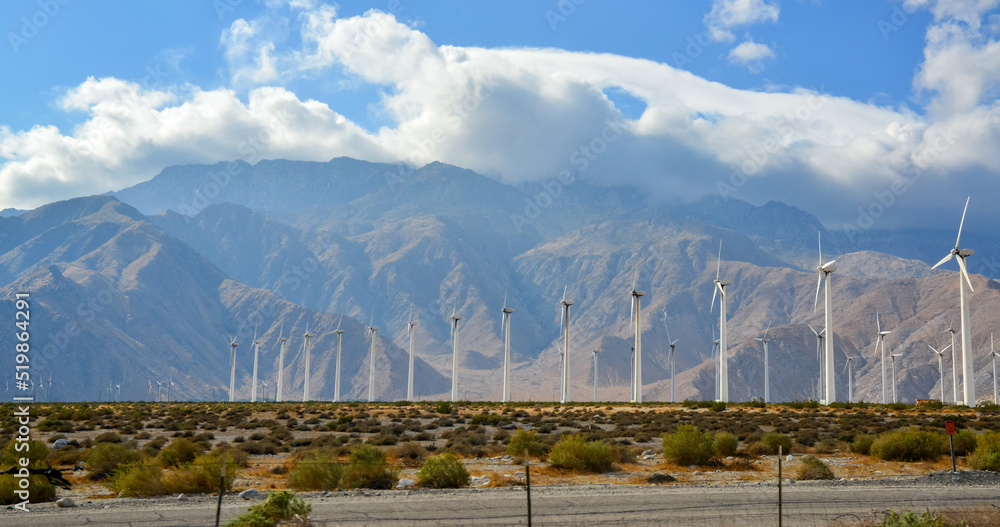 View of wind turbines generating electricity. Huge array of gigantic wind turbines spreading over the desert in Palm Springs wind farm, California View of wind turbines generating electricity. Huge array of gigantic wind turbines spreading over the desert in Palm Springs wind farm, California
