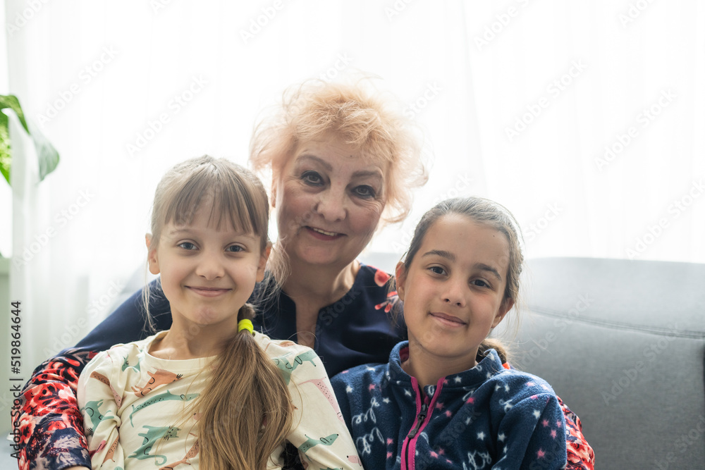 Smiling loving mature grandmother and two granddaughters