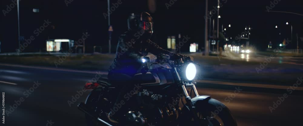 TRACKING Shot of a biker riding his custom built cafe racer motorcycle through city at night. Shot with 2x anamorphic lens TRACKING Shot of a biker riding his custom built cafe racer motorcycle through city at night. Shot with 2x anamorphic lens