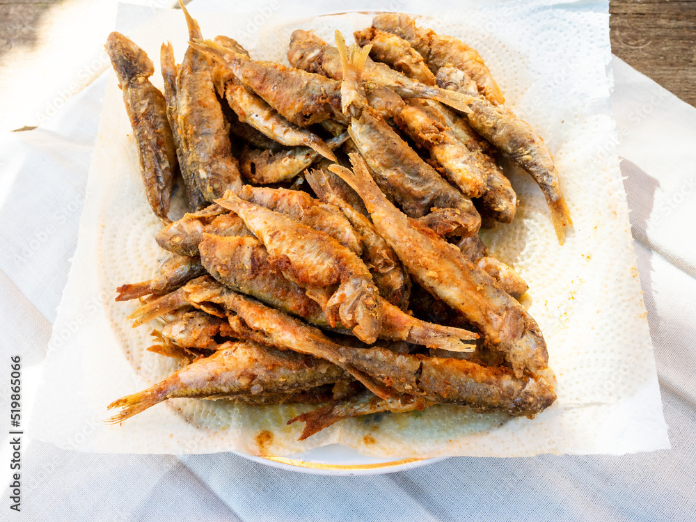 fried surmullet fishes on white paper napkin fried surmullet fishes on white paper napkin