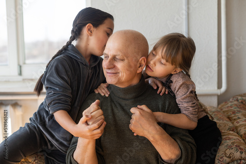 Ukrainian grandfather and two granddaughters hugging