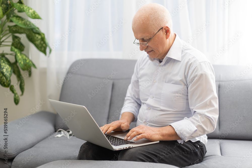 Happy old caucasian businessman smiling working online watching webinar podcast on laptop and learning education course conference calling make notes sit, elearning concept Happy old caucasian businessman smiling working online watching webinar podcast on laptop and learning education course conference calling make notes sit, elearning concept