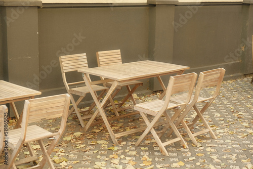 Beautiful wooden table with chairs near the cafe. Light wood table and chairs in the yard. Neat patio  photogenic table and chairs