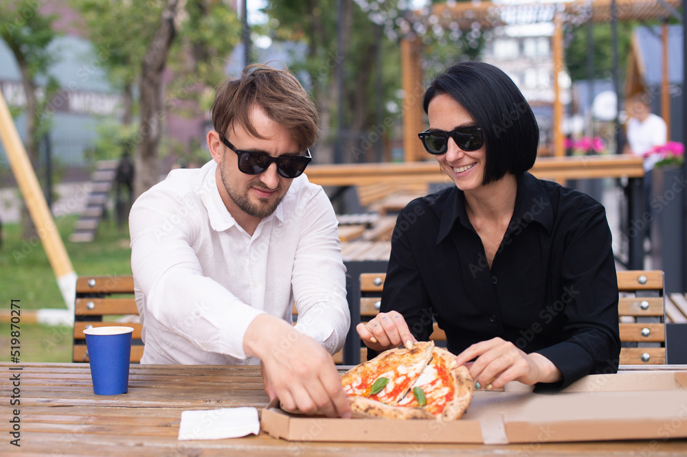 A guy and a girl share a pizza in a box A guy and a girl share a pizza in a box