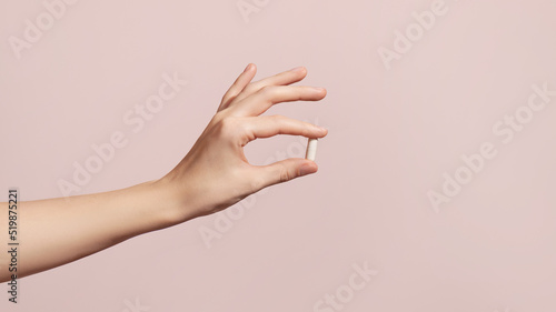 Photos Hand holding the supplements on pink background
