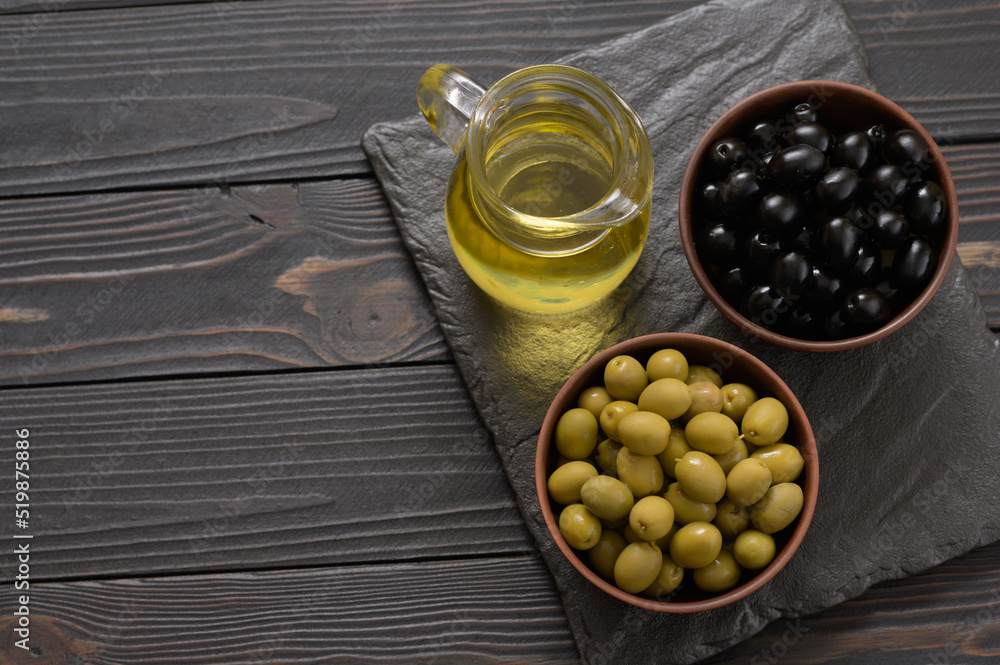 Black and green olives on a dark wooden rustic background.