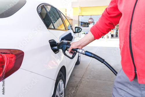 Pumping gas at gas pump. Closeup of man pumping gasoline fuel in car at gas station, rising gasoline prices, Copy Space.