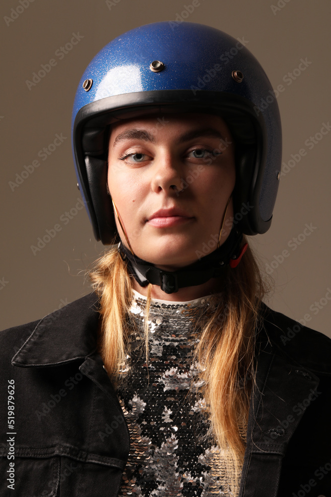 Vertical close-up of young woman wearing motor helmet poses indoor. Mock-up. Vertical close-up of young woman wearing motor helmet poses indoor. Mock-up.