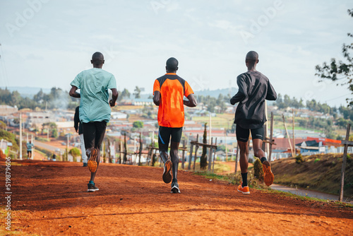 Morning running training. in Kenya. Marathon runners on red soil train in the light of the rising sun. Motivation to move. Endurance running  athletics and sports