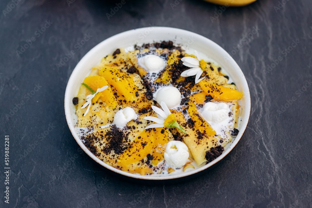 Sweet pancakes with ice cream, chocolate and orange served on white plate. Healthy and tasty breakfast Sweet pancakes with ice cream, chocolate and orange served on white plate. Healthy and tasty breakfast