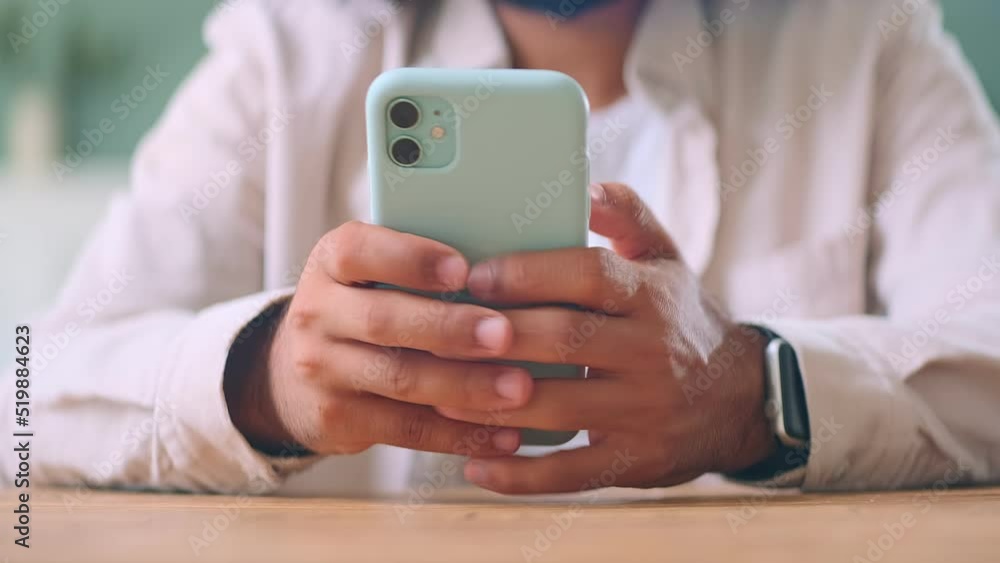 Hands man dialing SMS message on phone and registering in mobile application or website of online store for further shopping and making purchases sits at wooden table. Technology, internet