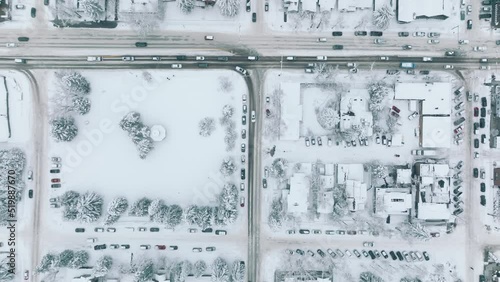 Top down aerial winter traffic in Aspen snowy village on cold winter day. Overhead cars driving slowly and carefully by streets covered with fresh snow in small town in Colorado. Christmas holidays 4K photo