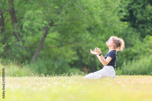 Fotografie Woman kneeling in field worshipping God