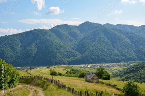 Beautiful rural landscape of Carpathian mountains and picturesque village Kolochava in the valley on a sunny summer day. Transcarpathia, Ukraine