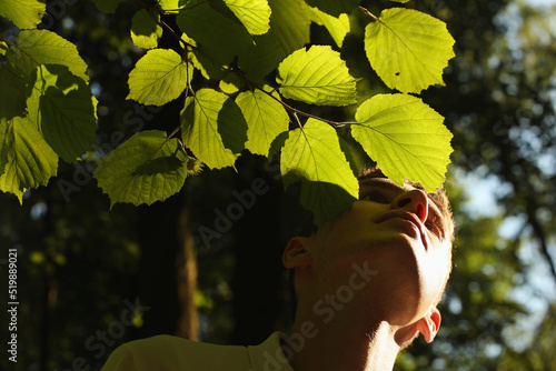 Young man face and green leaves in the summer forest. Pavel, my face and green leaves. Photo was taken 24 July 2022 year, MSK time in Russia. photo