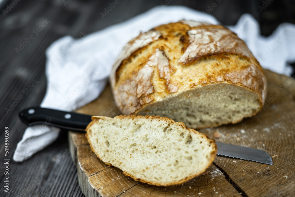 Traditional leavened sourdough bread cut into slice on a rustic wooden table. Healthy food photography Traditional leavened sourdough bread cut into slice on a rustic wooden table. Healthy food photography