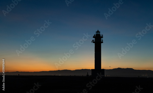 Lighthouse silhouette in Delta de l'ebro Spain during the sunset