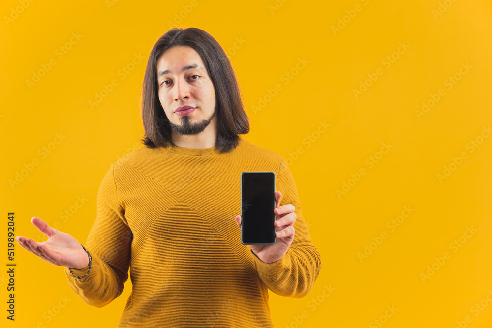 An isolated bearded European guy in his 30s showing screen of his phone in a studio. High quality photo An isolated bearded European guy in his 30s showing screen of his phone in a studio. High quality photo