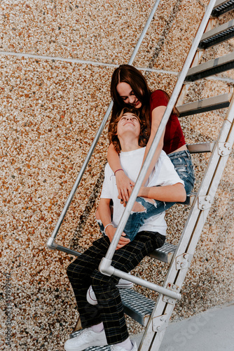 teen boy looking up at girlfriend as she smiles down on him