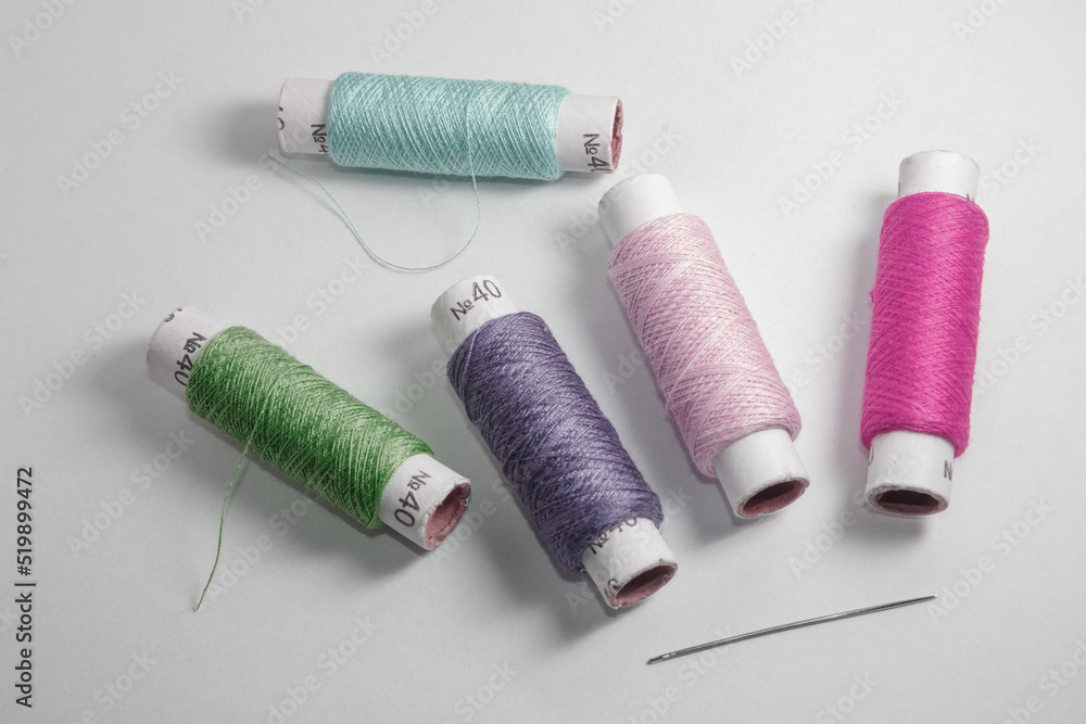 Green, grey, pink and purple threads on the white background Green, grey, pink and purple threads on the white background