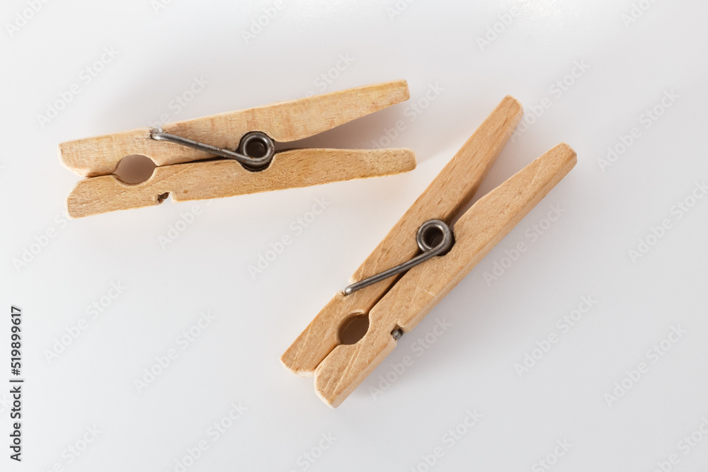 Two wooden clothespins on a white background