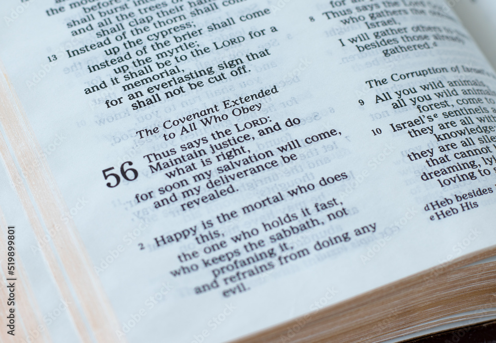 Obraz premium Open Holy Bible Book prophet Isaiah 56, God's covenant for all who obey His commandments. A close-up. Christian biblical concepts of justice, obedience, and trust.