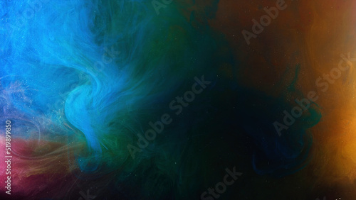Tiny glowing particles move in a colorful water. Stock footage. Stunning art background with paints reacting in water and creating beautiful cloud formations.