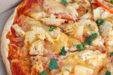 Pizza with pineapple, chicken, tomatoes and cheese