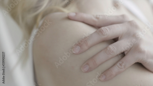 Close up for woman hand squeezeing her houlder, anxiety or worry concept. Action. Body parts, girl hand touching her gentle shoulder.