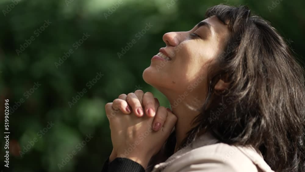 Hopeful woman praying to God standing outside looking at sky. Girl closing eyes in meditation. Contemplative person opening eye having HOPE Hopeful woman praying to God standing outside looking at sky. Girl closing eyes in meditation. Contemplative person opening eye having HOPE