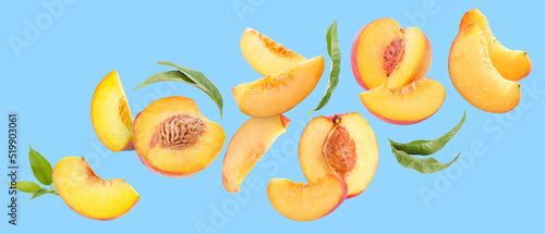Fototapeta Naklejka Na Ścianę i Meble -  Flying ripe cut peaches on blue background