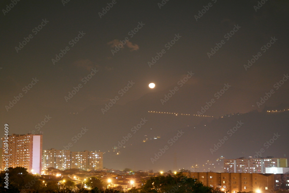 Urban view of the moon in the night sky
