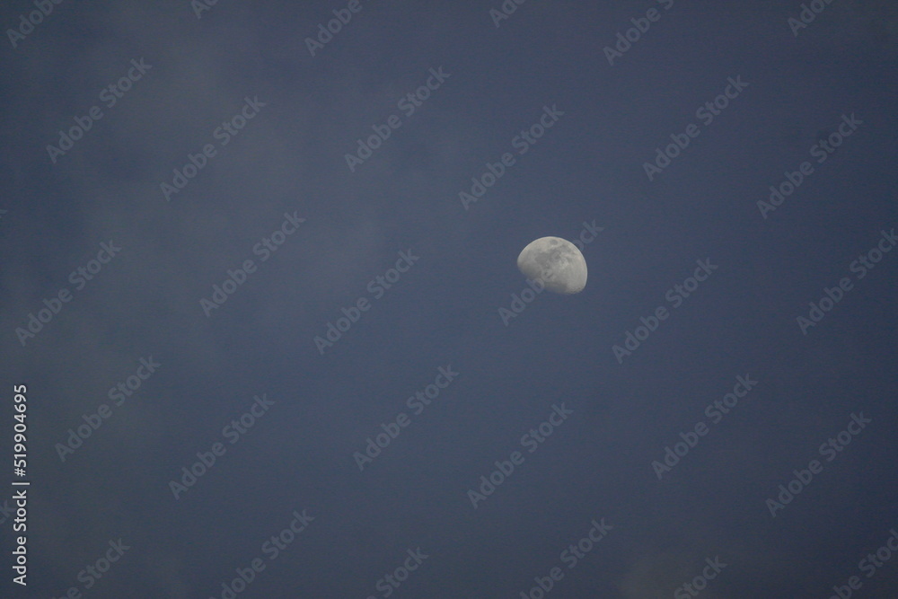 Urban view of the moon in the night sky Urban view of the moon in the night sky