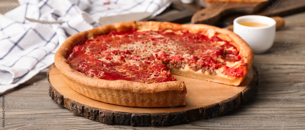 Tasty Chicago-style pizza on wooden table Tasty Chicago-style pizza on wooden table