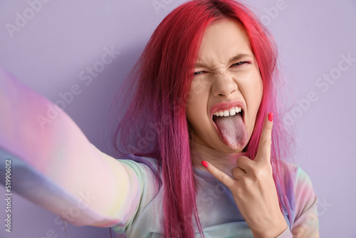 Beautiful young woman with bright hair showing 