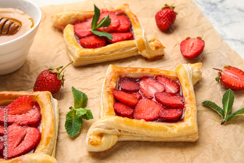 Delicious strawberry puff pastry on parchment, closeup