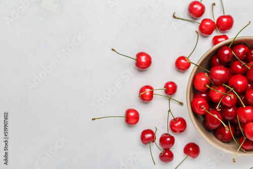 Bowl of sweet cherries on light background