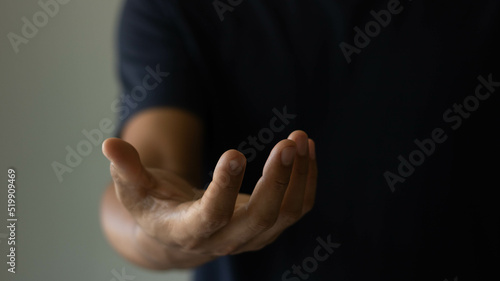Businessman showing empty hand and presenting with hand empty copy space. The man is standing and shows an outstretched hand with an open palm. Open hand, Holding, giving, showing, presenting concept photo
