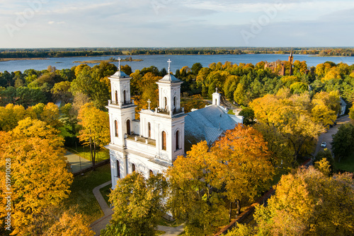 Beautiful aerial view of St. John the Baptist's Church in Birzai surrounded by autumn vegetation on sunny fall day. photo